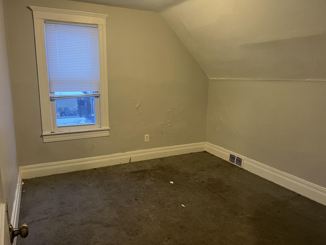 bonus room with baseboards, visible vents, vaulted ceiling, and carpet flooring