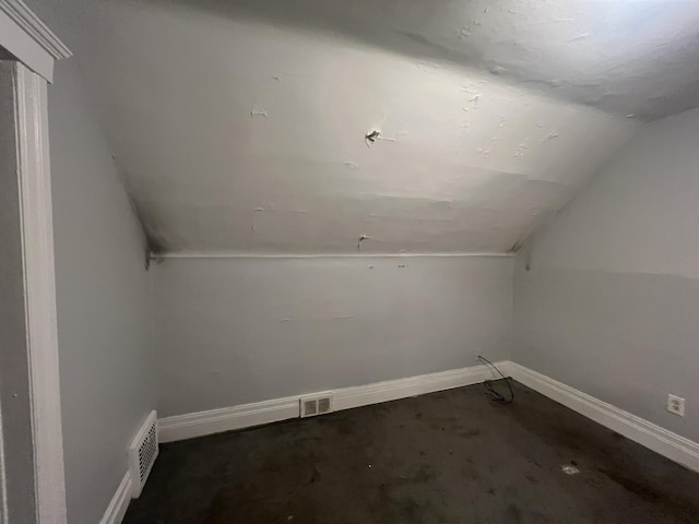 additional living space featuring lofted ceiling, visible vents, and baseboards