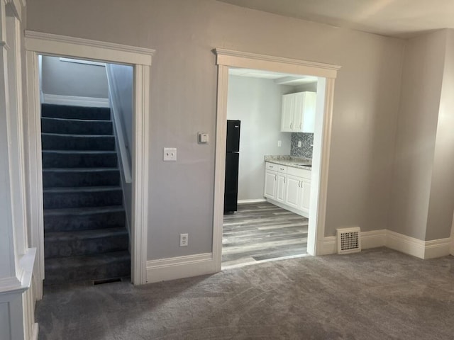 interior space with stairs, visible vents, and baseboards