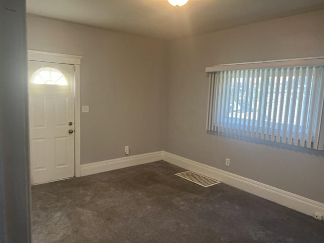 carpeted entrance foyer featuring visible vents and baseboards