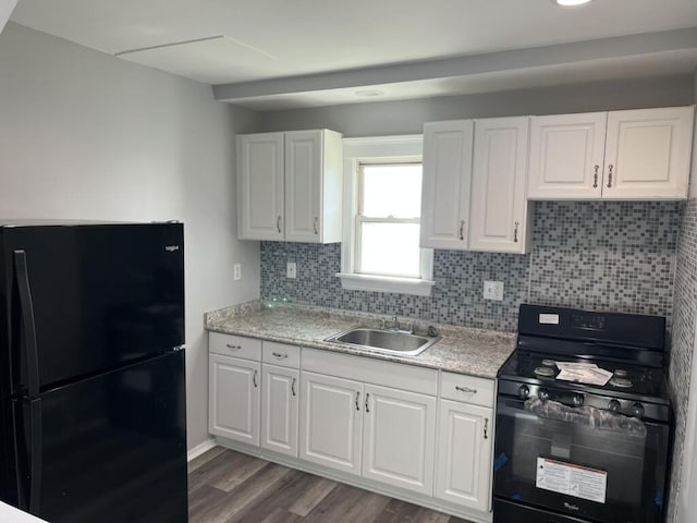 kitchen with black appliances, tasteful backsplash, a sink, and light countertops