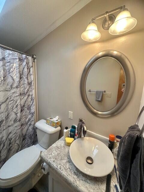 full bathroom featuring toilet, curtained shower, ornamental molding, and vanity