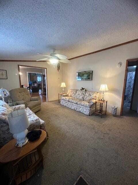 carpeted living area featuring ceiling fan, a textured ceiling, and crown molding