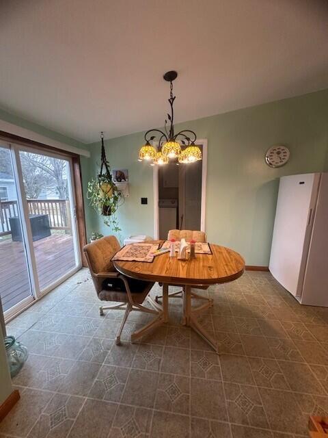 dining room featuring a chandelier and baseboards