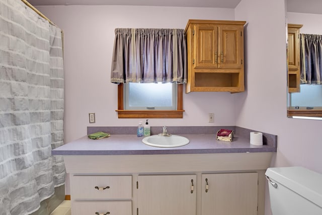 bathroom with toilet, a shower with shower curtain, and vanity