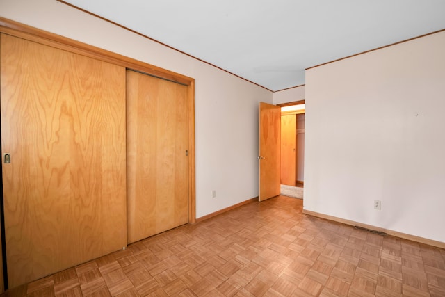 unfurnished bedroom featuring baseboards, visible vents, and a closet