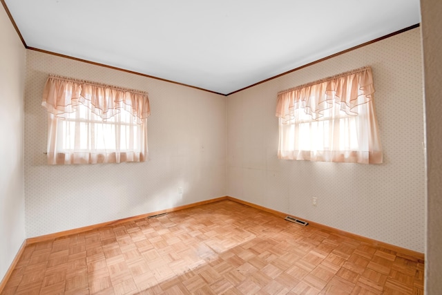 empty room featuring wallpapered walls, baseboards, visible vents, and crown molding