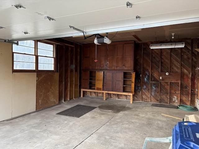 garage featuring wood walls and a garage door opener