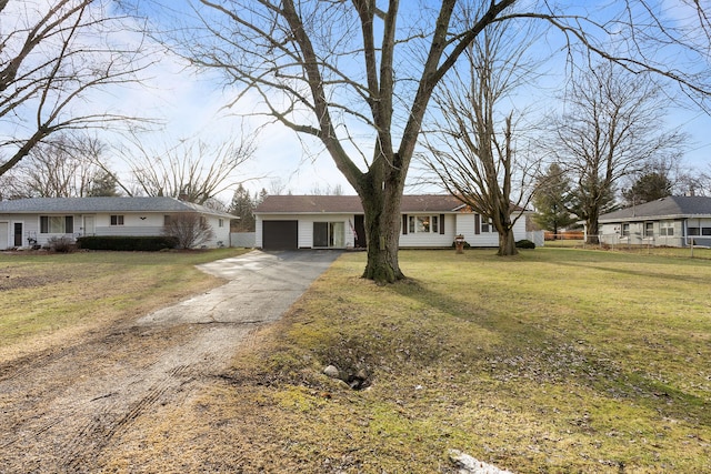 view of front of property with an outbuilding, aphalt driveway, a front lawn, and a garage