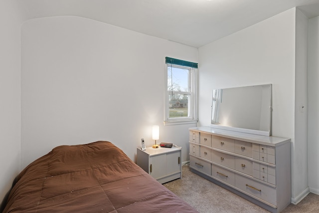 bedroom with light carpet and baseboards