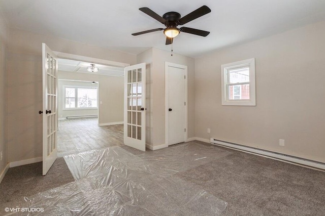 empty room featuring french doors, baseboards, and baseboard heating