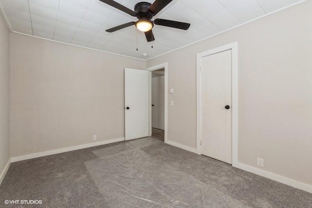 unfurnished bedroom featuring carpet flooring, a ceiling fan, and baseboards