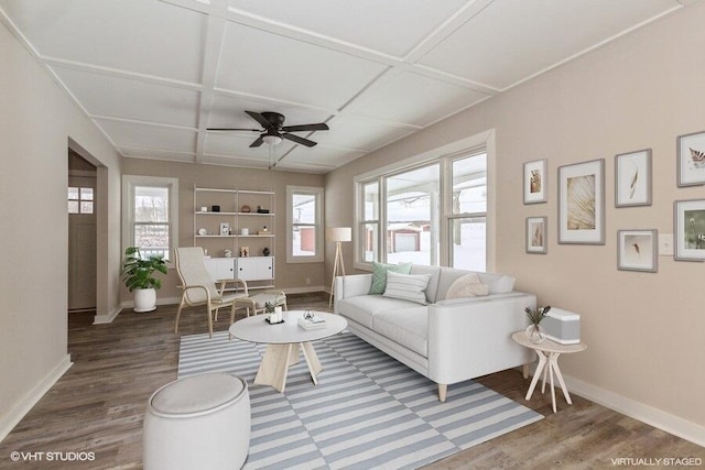 living area featuring baseboards, coffered ceiling, and wood finished floors