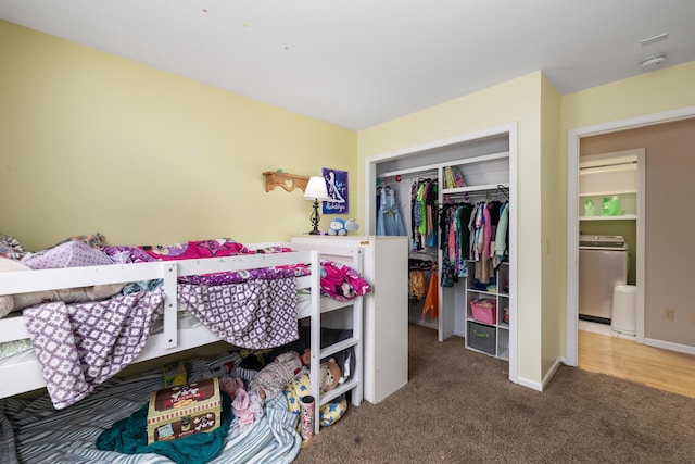 carpeted bedroom with washer / clothes dryer, a closet, and baseboards