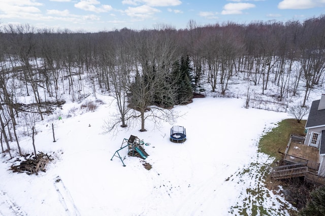 snowy aerial view featuring a forest view