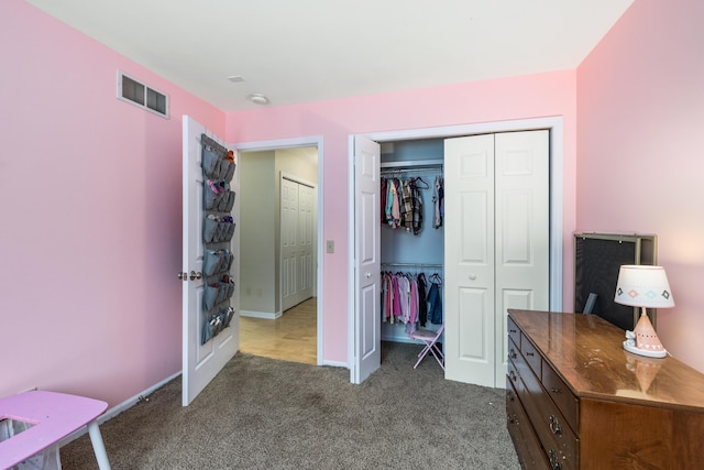 bedroom with baseboards, a closet, visible vents, and carpet flooring