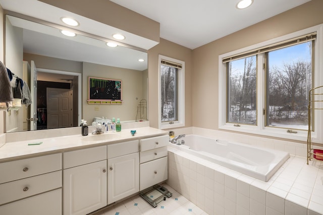 full bath with vanity, a bath, and recessed lighting