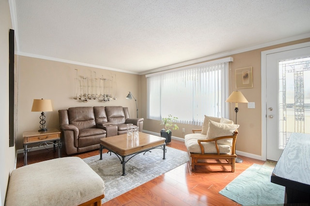 living area featuring a textured ceiling, baseboards, light wood-type flooring, and ornamental molding