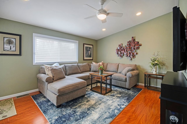 living area with wood finished floors, visible vents, and baseboards