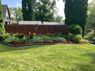 exterior space featuring a lawn and fence