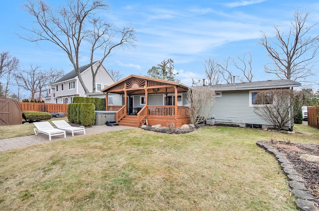 view of front of home featuring a wooden deck, a front lawn, and fence