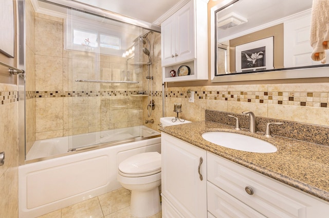 full bathroom with tile walls, toilet, tile patterned floors, combined bath / shower with glass door, and vanity