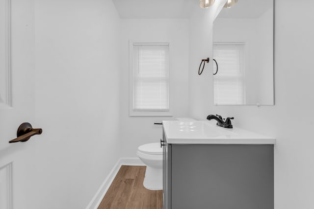 bathroom featuring baseboards, vanity, toilet, and wood finished floors