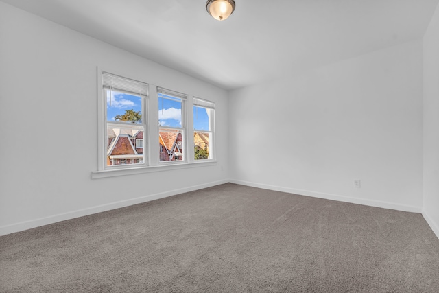 spare room featuring carpet floors and baseboards