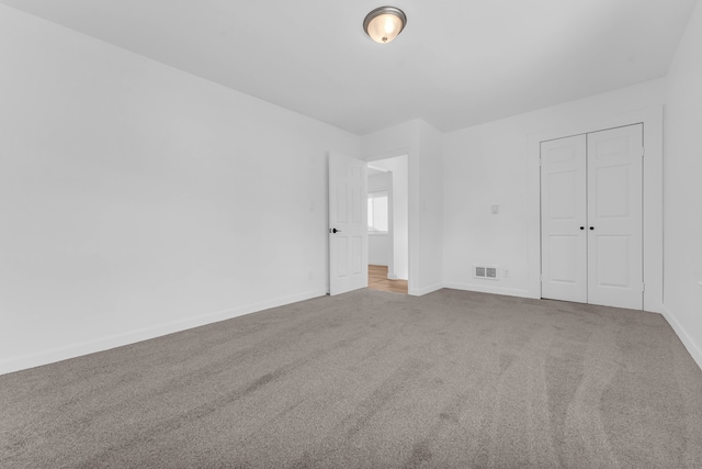 unfurnished bedroom with carpet floors, a closet, visible vents, and baseboards