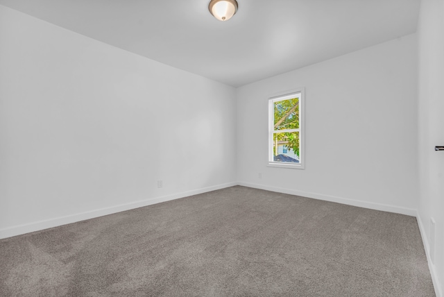 carpeted empty room with baseboards