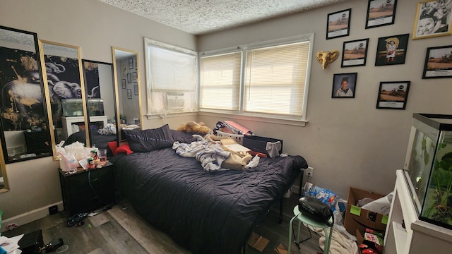 bedroom with a textured ceiling and wood finished floors