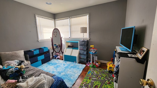 bedroom with baseboards and wood finished floors