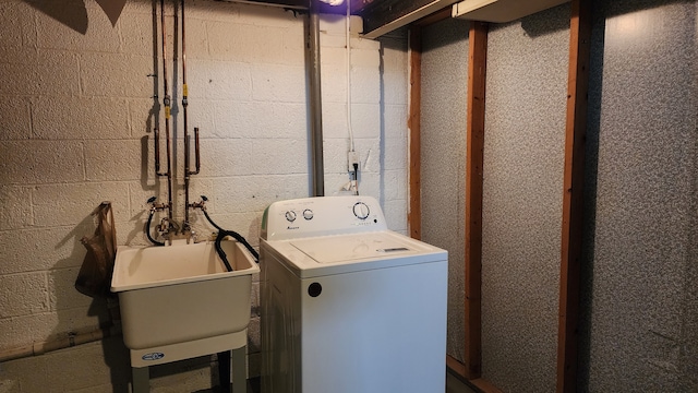 clothes washing area with a sink and washer / dryer