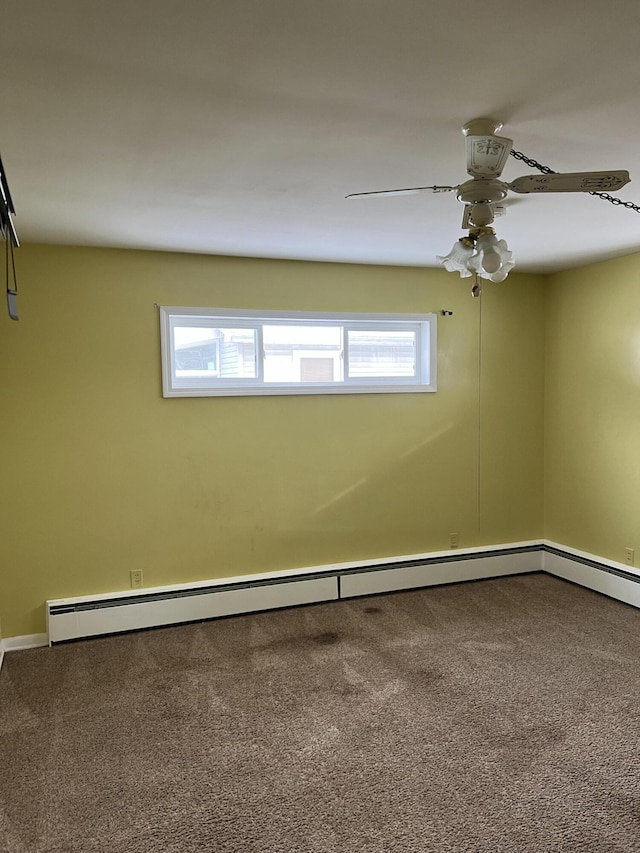 carpeted spare room featuring a wealth of natural light, ceiling fan, and baseboard heating