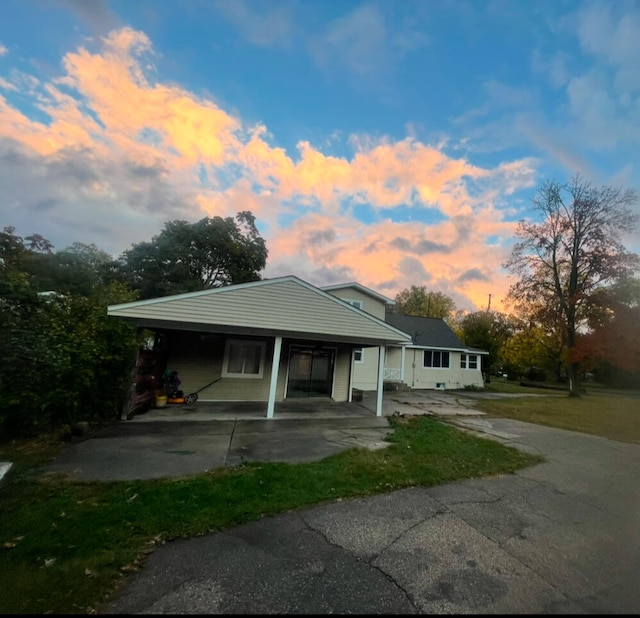 bungalow-style home featuring driveway, a carport, and a front yard