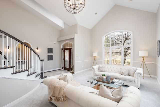 living area with high vaulted ceiling, an inviting chandelier, carpet flooring, baseboards, and stairs