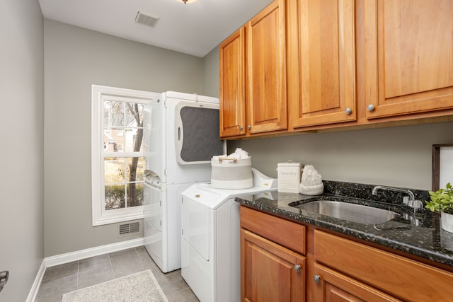 washroom featuring visible vents, cabinet space, washer / clothes dryer, and a sink