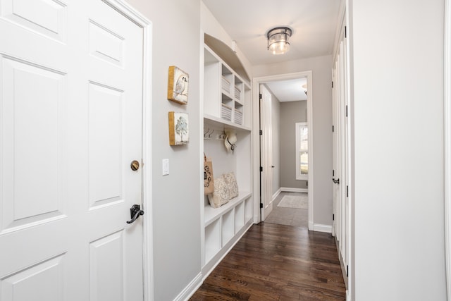 corridor featuring dark wood-style floors and baseboards