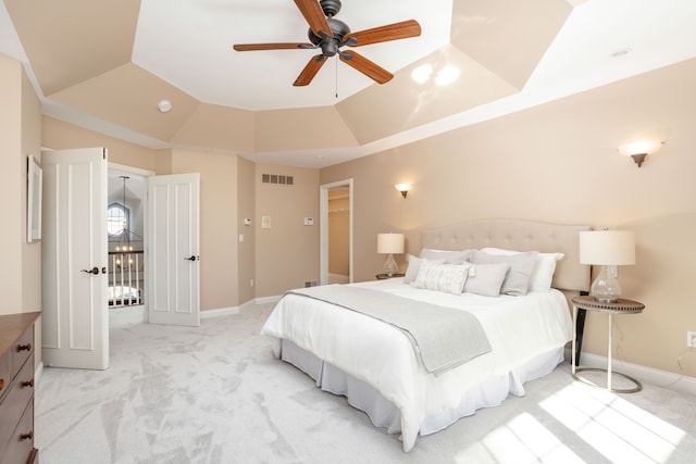 bedroom featuring light carpet, visible vents, baseboards, and lofted ceiling