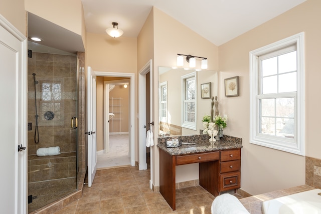 bathroom with tile patterned flooring, a stall shower, vanity, and lofted ceiling