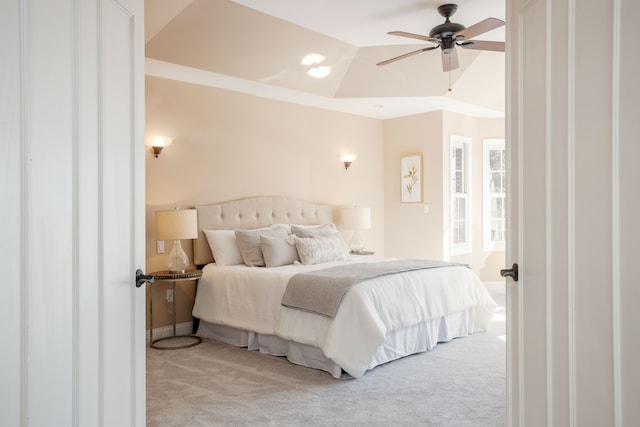 bedroom with a tray ceiling, carpet, and a ceiling fan