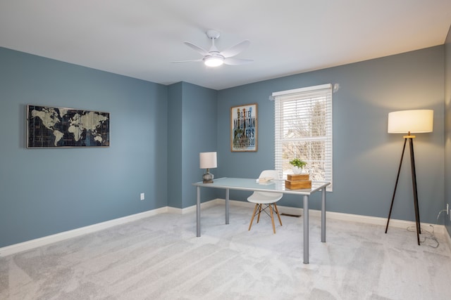 carpeted home office featuring baseboards and ceiling fan