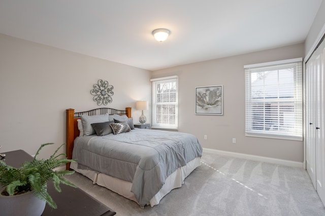 bedroom with baseboards and light carpet