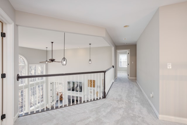 hallway with baseboards and carpet