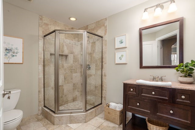 bathroom with toilet, a stall shower, and vanity