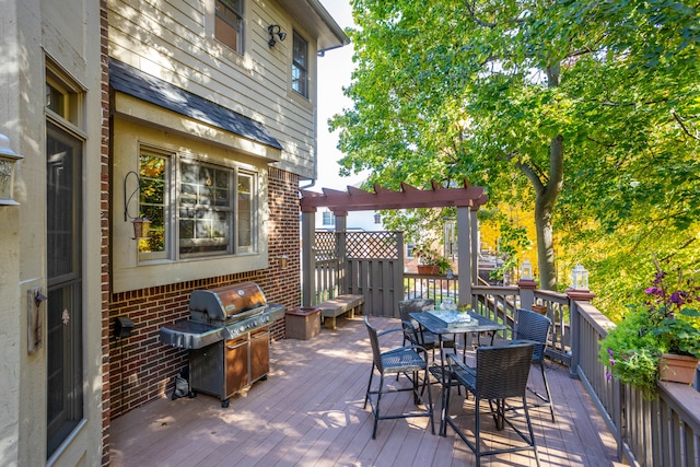 wooden terrace with outdoor dining area and area for grilling