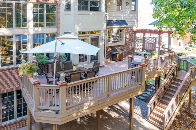 deck with outdoor dining space, area for grilling, and a pergola