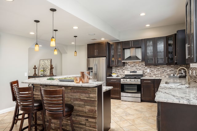 kitchen featuring a sink, backsplash, a center island, appliances with stainless steel finishes, and wall chimney exhaust hood