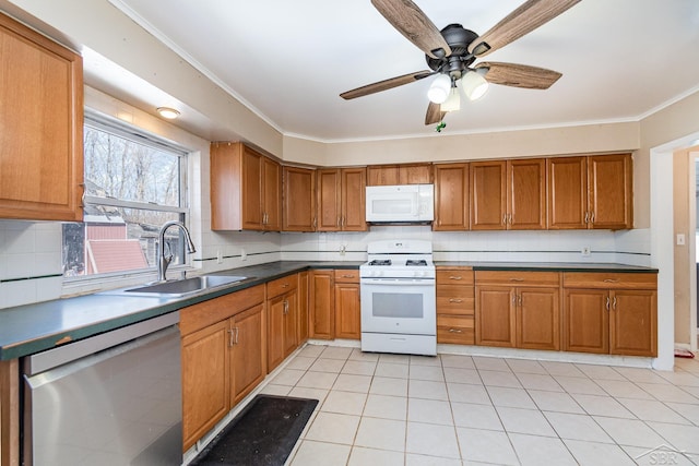 kitchen with white appliances, brown cabinets, a sink, and decorative backsplash