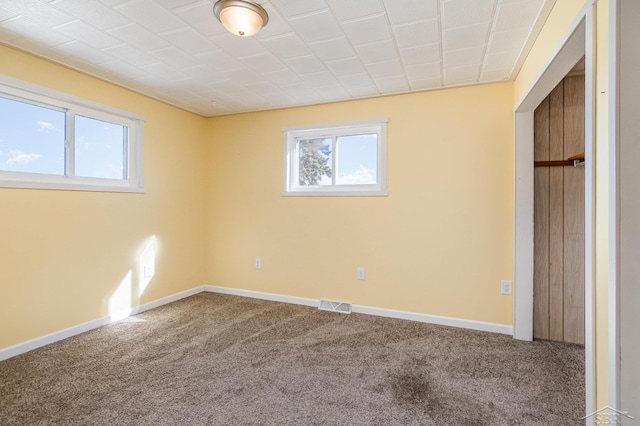 unfurnished bedroom with multiple windows, visible vents, and carpet